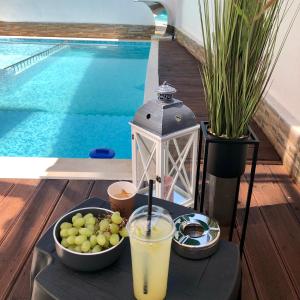 un vassoio con una bevanda e un cesto di frutta accanto alla piscina di Family Hotel Ring & Thermal a Kjustendil