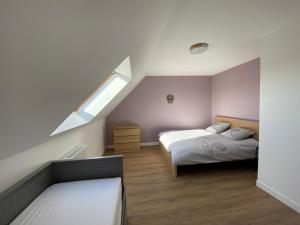 - une chambre mansardée avec 2 lits et une lucarne dans l'établissement Jolie maison avec SPA à la campagne !, 