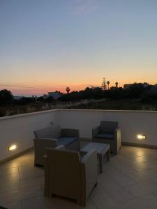 un patio con divani, sedie e tramonto di Casa Monica a Torre Vado