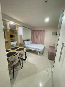 um quarto com uma cama, uma mesa e cadeiras em Free WI-FI and Pool Persimmon Condominium em Cebu