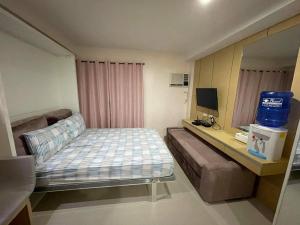 um quarto com uma cama e uma secretária com uma televisão em Free WI-FI and Pool Persimmon Condominium em Cebu
