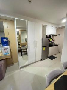 eine Küche mit einem Kühlschrank und einem Tisch darin in der Unterkunft Free WI-FI and Pool Persimmon Condominium in Cebu City