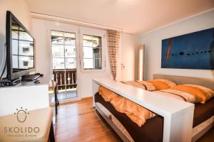 um quarto com uma cama e uma televisão em Wohnung in Zermatt mit postkarten Matterhornblick em Zermatt