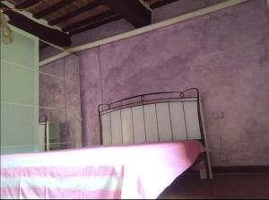 Schlafzimmer mit einem Bett und einem Spiegel in der Unterkunft Casa Contadina in borgo medievale, Tuscany in Monteguidi