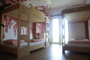 a bedroom with two bunk beds and a window at Arthouse Surf Ericeira in Ericeira
