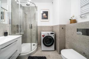 La salle de bains est pourvue d'une douche et d'un lave-linge. dans l'établissement Rent like home - Gwiaździsta 20, à Wrocław