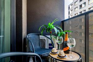 - une table avec des verres à vin et une plante sur le balcon dans l'établissement Rent like home - Gwiaździsta 20, à Wrocław