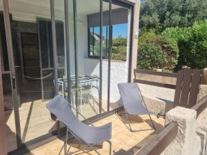 a patio with chairs and a table on a balcony at Studio 2 adultes 2 enfants Sanary sur Mer à 800m de la mer in Sanary-sur-Mer