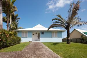 a blue house with a palm tree and a driveway at Villa Gauguin in Sainte-Rose
