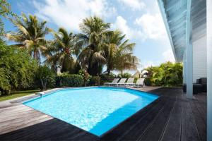 a swimming pool on a deck next to a house at Villa Gauguin in Sainte-Rose