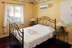 a bedroom with a bed and two lamps and a window at Villa Gauguin in Sainte-Rose