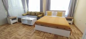a bedroom with a large bed and a couch at Studios near to Burgas Free University in Burgas City