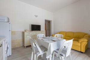 a living room with a table and a yellow couch at Villa La Fenice by BarbarHouse in San Pietro in Bevagna