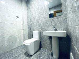 a bathroom with a toilet and a sink at Chez El Hadji et Hamidou in Dakar