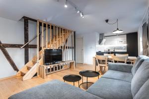 a living room with a couch and a tv and a table at Apartmány VOLF - Boží Dar in Boží Dar