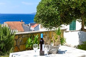 eine Flasche Wein auf einem Tisch mit Brille in der Unterkunft Villa Grande Vista - Lovely Apartment with Private spacious lush mediterranean patio and Sea view in Trogir
