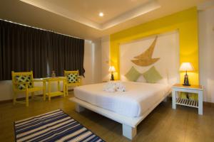 1 dormitorio con 1 cama, mesa y sillas en The Blue Pearl Kata Hotel, en Kata Beach