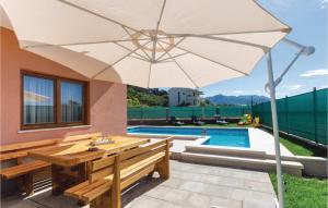 une terrasse avec une table en bois et un parasol dans l'établissement Holiday Apartment In Solin, à Solin