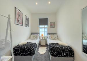 una habitación con dos camas y un espejo en A Stones Throw By My Getaways, en Brighton & Hove