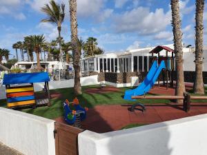 Un parque infantil con un tobogán y un tobogán. en Las Brisas 71, en Playa Blanca