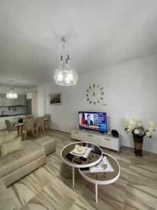 a living room with a couch and a table and a tv at Modern One Bedroom Apartment Saranda Terraces in Sarandë