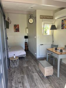 a bedroom with a bed and a desk and a table at La Cuisine d'été de BeaunAmour in Beaune