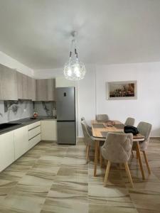 a kitchen and dining room with a table and chairs at Modern One Bedroom Apartment Saranda Terraces in Sarandë