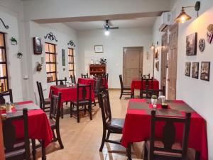 un restaurant avec des tables et des chaises rouges dans une salle dans l'établissement Hotel Los Monteros, à Ciudad Victoria