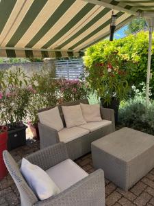 a patio with a couch and chairs under a canopy at La Cuisine d'été de BeaunAmour in Beaune