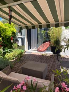 a patio with a table and a chair and some plants at La Cuisine d'été de BeaunAmour in Beaune