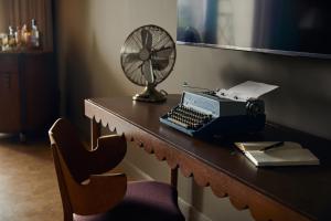 a desk with a typewriter and a fan on it at Mayfair House Hotel & Garden in Miami