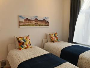 Un dormitorio con dos camas y un cuadro en la pared. en Chez Esmara et Philippe Grand-Place, en Bruselas