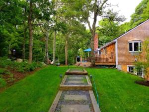 a yard with a house and a lawn with a hose at CAPE COD'S BEST BEACH GETAWAY in Falmouth