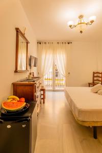 Habitación con cama y cocina con fogones. en Hotel Cafe La Morena, en Fuengirola
