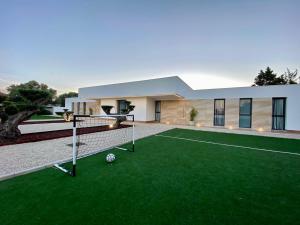 ein Haus mit einem Fußball auf dem Rasen in der Unterkunft VISTA LAGO VILLE in Chiclana de la Frontera