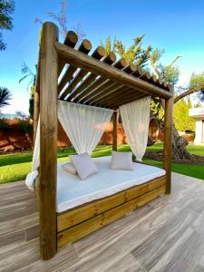 ein Holzbett mit Baldachin auf einer Terrasse in der Unterkunft VISTA LAGO VILLE in Chiclana de la Frontera