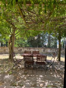 uma mesa de madeira e cadeiras debaixo de uma árvore em Agriturismo I Moricci em Peccioli