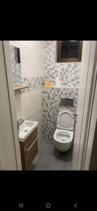 a small bathroom with a toilet and a sink at Apartman Vukoja in Grude