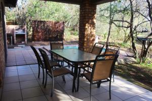 a black table and chairs on a patio at Nature House in Marloth Park