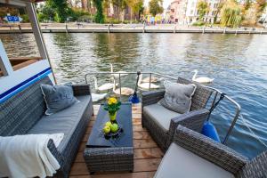 a boat with wicker chairs and a table on the water at Lisa Boot 1 in Priepert