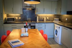 a kitchen with a wooden table with red chairs at Cosy Cottage in Fishertown, Nairn - Free Parking & Pets welcome! in Nairn
