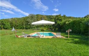 - une piscine avec 2 chaises et un parasol dans l'établissement 3 Bedroom Amazing Home In Citt Di Castello pg, à Lugnano