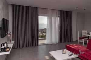 a living room with a red couch and a large window at Angel Saranda Palace in Sarandë