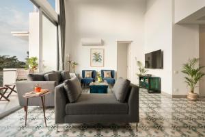 a living room with a couch and a tv at El Reino by The Blue Kite - 2 & 3BHK Apartments, 5 Mins to Casino & 10 Mins to Candolim, with Pool & Kitchen, Wifi, Security in Verem