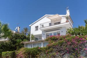 a white house with flowers in front of it at Casa Pura Vida in Estepona