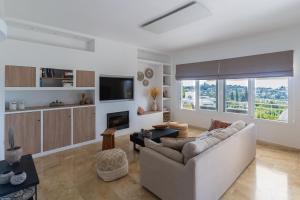 a living room with a couch and a tv at Casa Pura Vida in Estepona