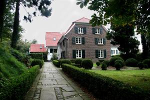 a brick house with a walkway in front of it at Landhaus in idyllischer, ruhiger Lage und Flughafennähe in Ratingen