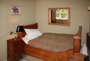 a bedroom with a wooden bed and a mirror at Landhaus in idyllischer, ruhiger Lage und Flughafennähe in Ratingen