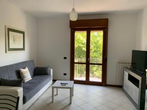 ein Wohnzimmer mit einem Sofa und einem TV in der Unterkunft I Platani 3 in Montecatini Terme