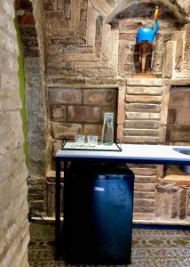 Guest House & Art Gallery في أوليندا: طاولة في غرفة مع جدار حجري
